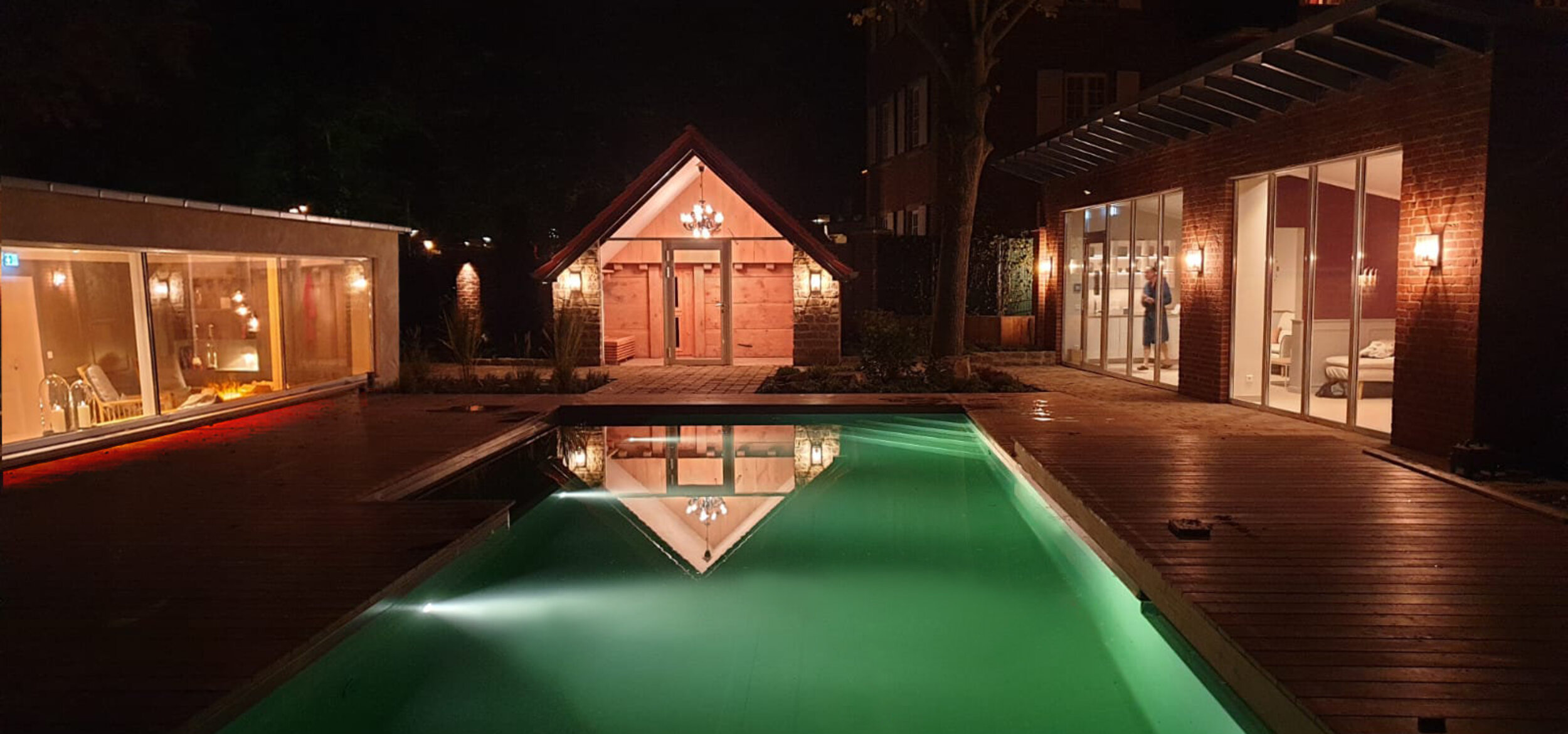 Der Naturpool des Hotel-Residence „Klosterpforte” in Marienfeld mit eingeschalteter Beleuchtung in der Nacht