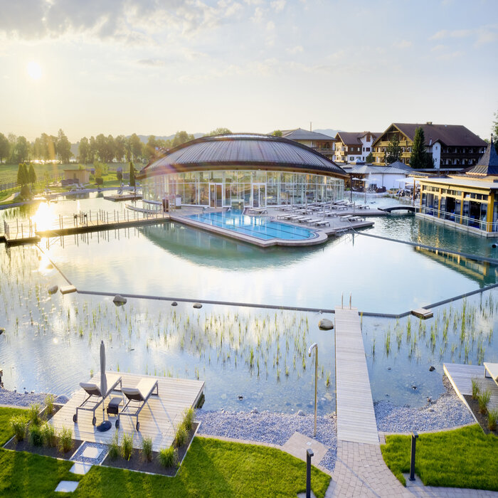Die Poollandschaft mit Balena-System des „König Ludwig” Wellness & SPA Resort mit Badeliegen und Bepflanzung